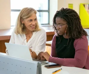 A young student with dyslexia sat next to her tutor